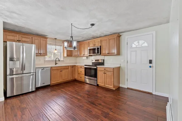 a kitchen with a refrigerator cabinets and wooden floor