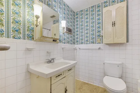 a bathroom with a sink a toilet and a mirror