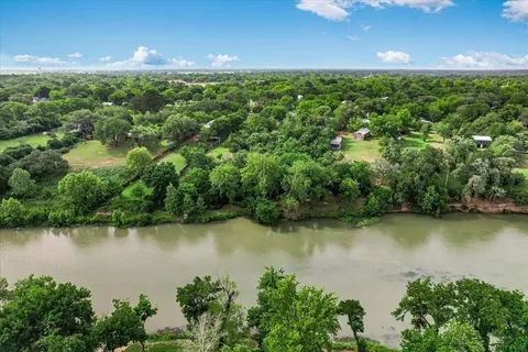 an aerial view of a houses with a yard and lake view