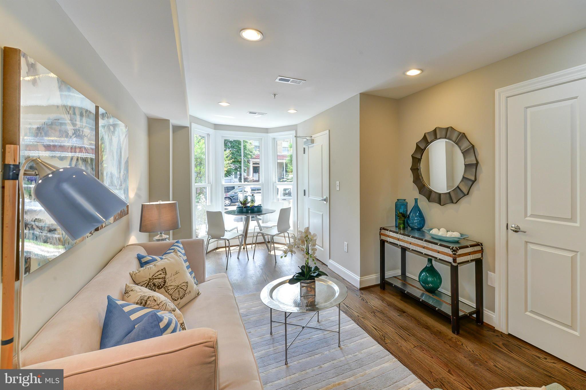 1823 S Street Northwest, Unit 3 Washington, DC 20009 - Photo 2 of 24 a living room with furniture a fireplace and a floor to ceiling window