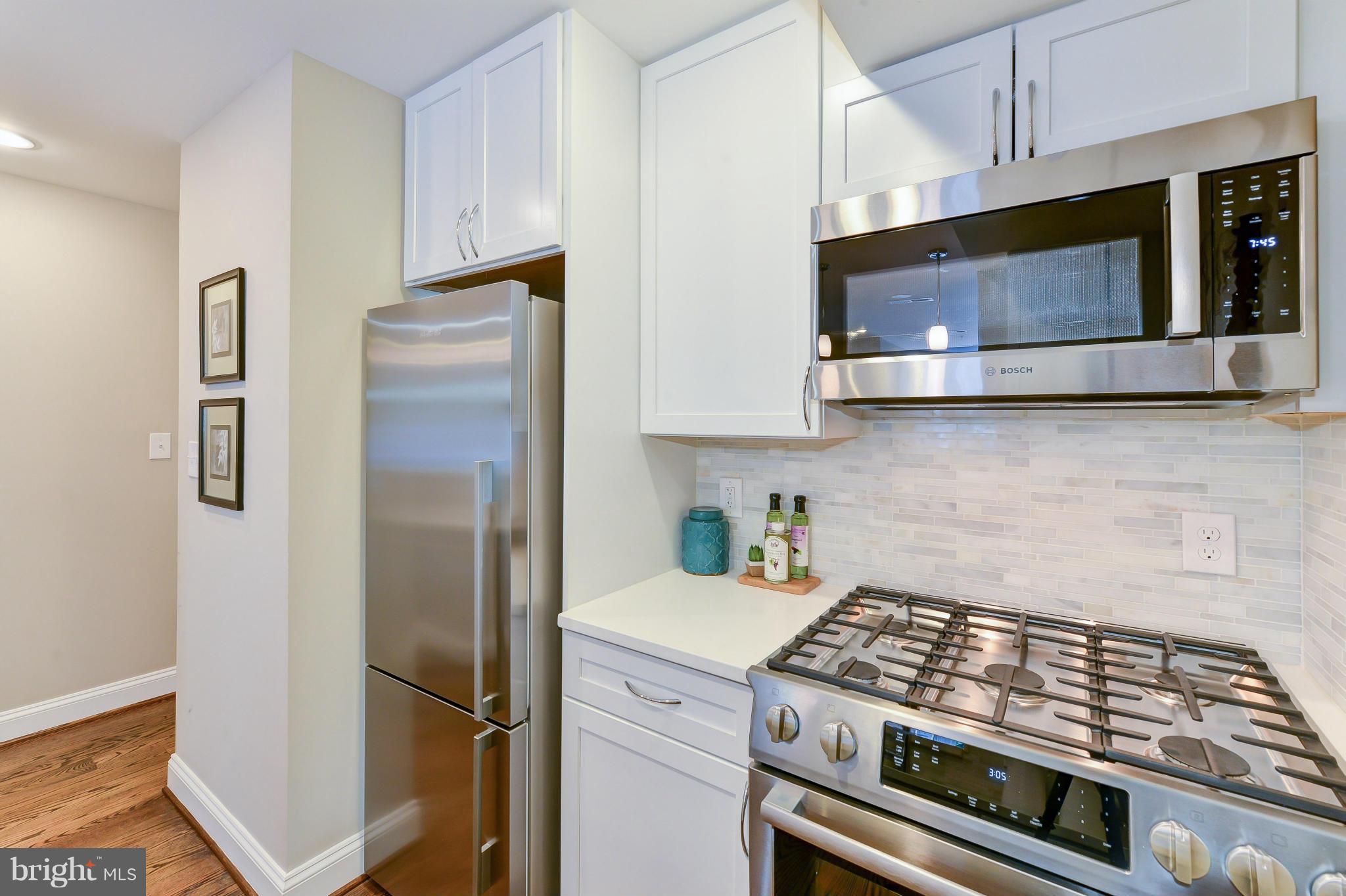 1823 S Street Northwest, Unit 3 Washington, DC 20009 - Photo 12 of 24 a kitchen with stainless steel appliances white cabinets and a stove top oven