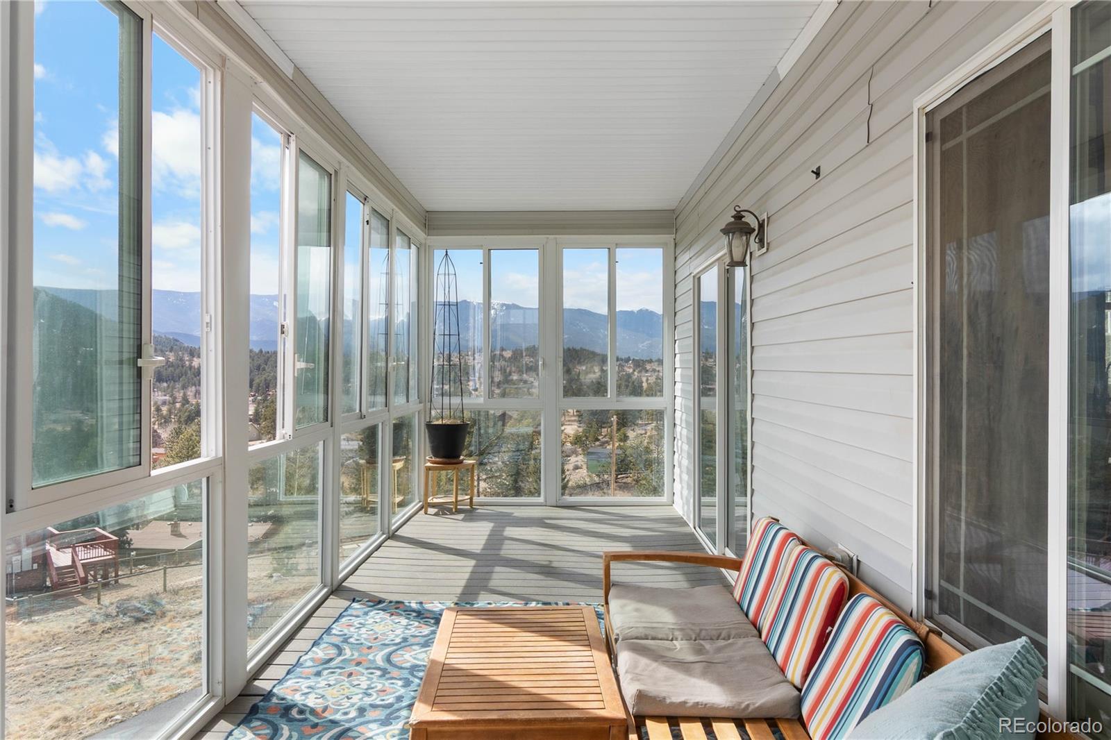 147 Overlook Drive Bailey, CO 80421 - Photo 13 of 43 a room with two large windows and a rug