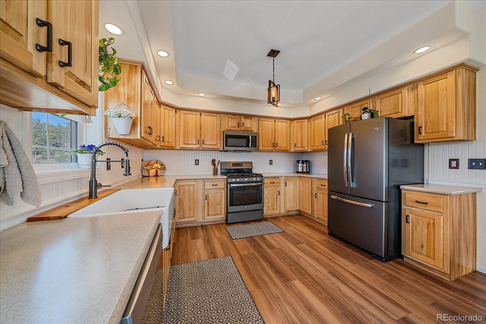147 Overlook Drive Bailey, CO 80421 - Photo 10 of 43 a kitchen with stainless steel appliances granite countertop a refrigerator a stove oven a sink dishwasher and white cabinets with wooden floor