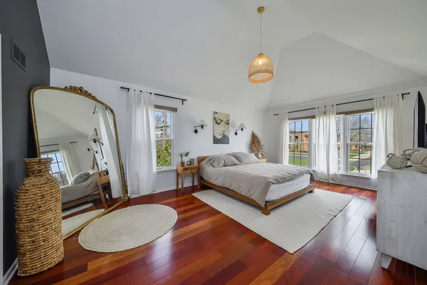 a bedroom with wooden floor and a bed