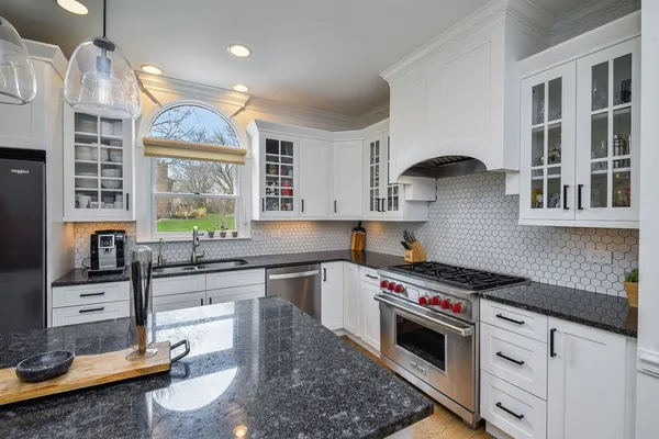 a kitchen with stainless steel appliances granite countertop a stove a sink and a granite counter tops