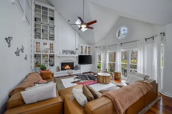 a living room with furniture a large window and a fireplace