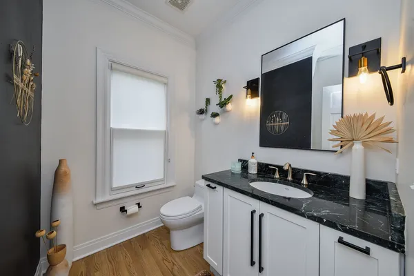 a bathroom with a granite countertop sink toilet and mirror