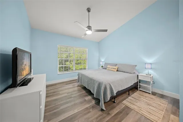 a bedroom with a bed tv on table and a window