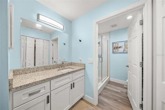 a bathroom with a granite countertop sink and a mirror