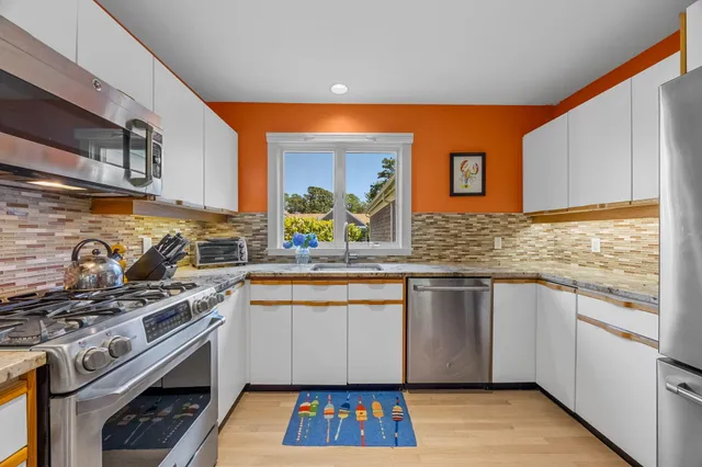 a kitchen with granite countertop cabinets stainless steel appliances and a sink