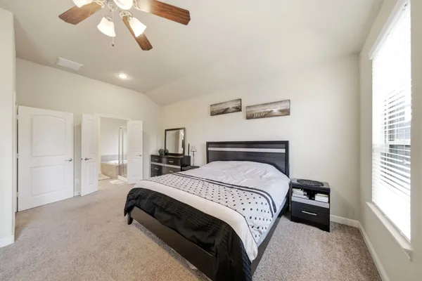 a bedroom with a bed and a large mirror