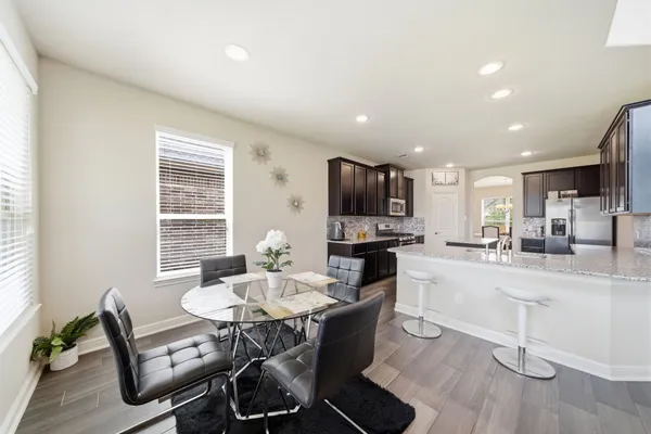 a kitchen with a dining table chairs and flat screen tv