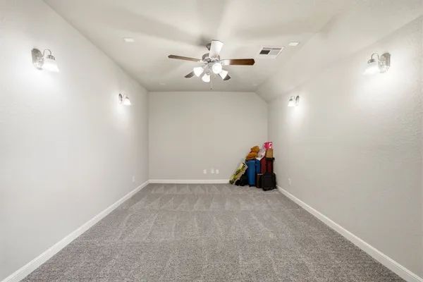 an empty room with closet and ceiling fan