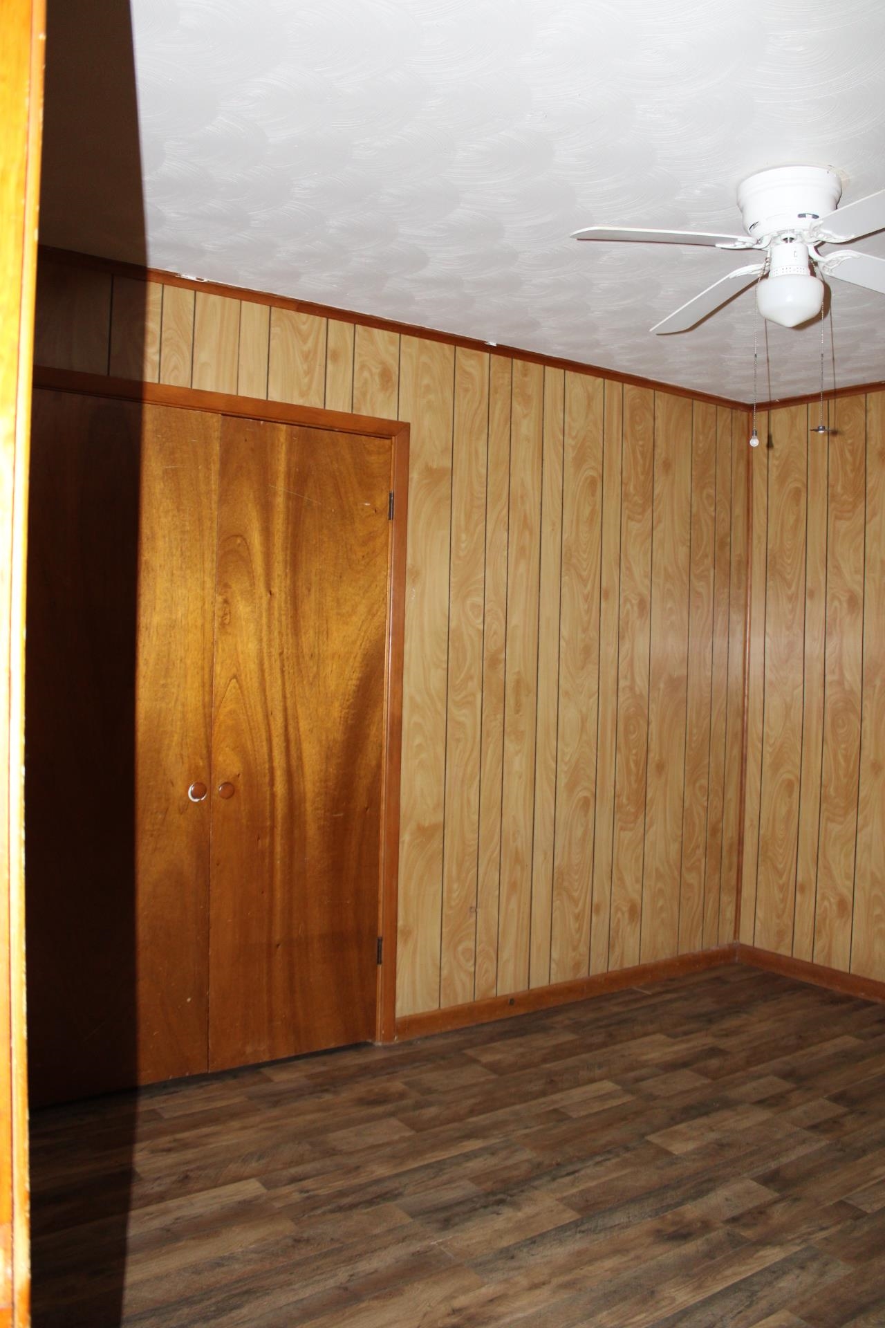 584 Chisholm Lake Road Ripley, TN 38063 - Photo 21 of 28 a view of a room with wooden floor and a ceiling fan