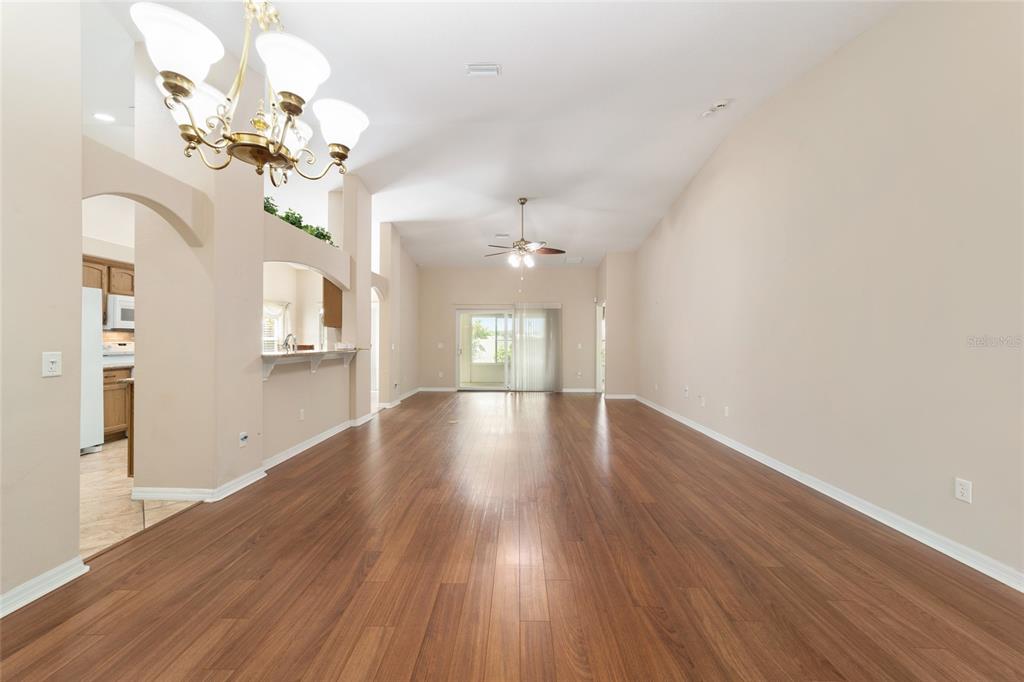 16369 Southwest 14th Avenue Road Ocala, FL 34473 - Photo 10 of 49 a view of an empty room with wooden floor and a chandelier