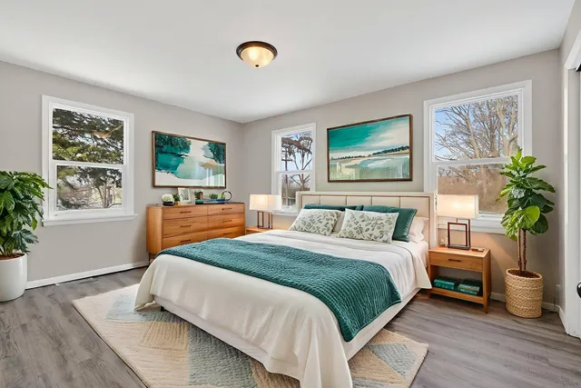 a view of an empty room with window and wooden floor