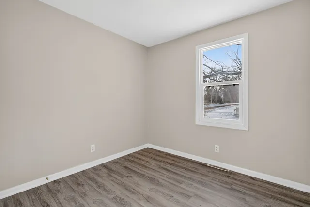 a view of an empty room with wooden floor