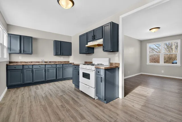 a spacious bedroom with a large bed a potted plant and a window
