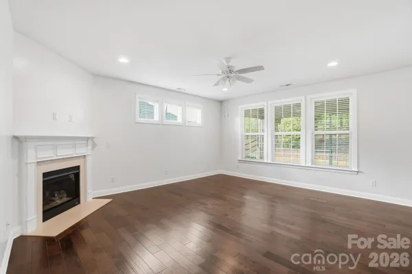 an empty room with windows and fireplace