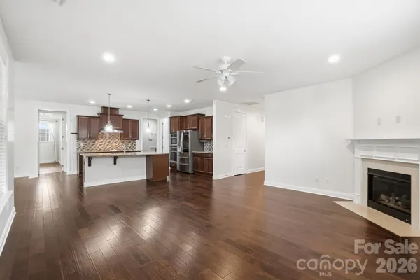 a view of kitchen with kitchen island wooden floor and a refrigerator