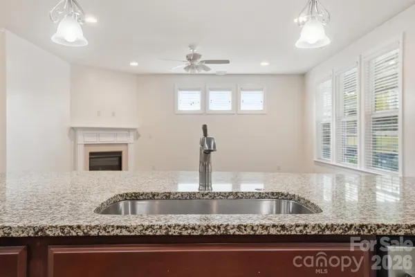 a bathroom with a granite countertop sink and a window