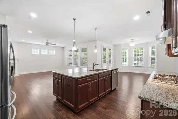 a kitchen with stainless steel appliances granite countertop a stove and a wooden floors