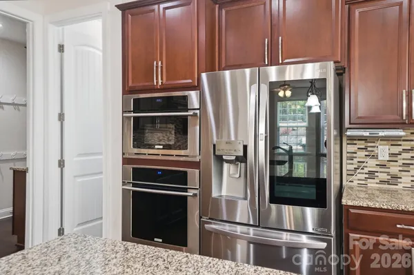 a kitchen with granite countertop stainless steel appliances and refrigerator