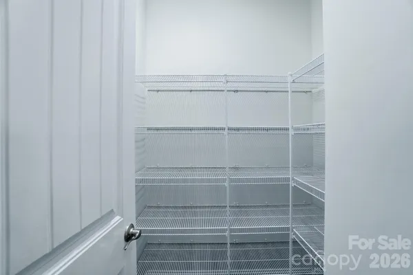a view of walk in closet with empty racks