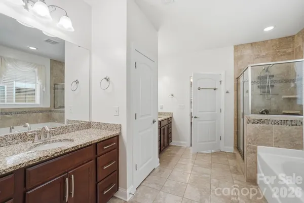 a spacious bathroom with a granite countertop sink a mirror and a shower