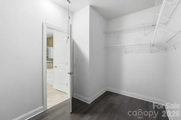 an empty room with a chandelier fan and windows
