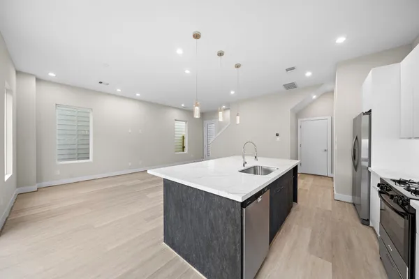 a kitchen with a sink a counter top space stainless steel appliances and a window