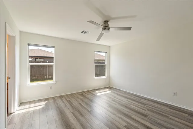 a view of empty room with wooden floor