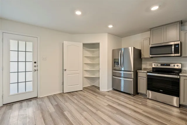 a kitchen with a refrigerator and a stove top oven
