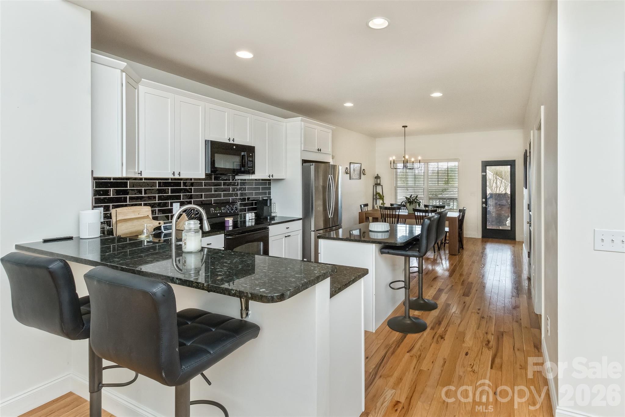 84 Rose Creek Road Leicester, NC 28748 - Photo 6 of 28 a kitchen with stainless steel appliances granite countertop a refrigerator a stove a sink a dining table and chairs