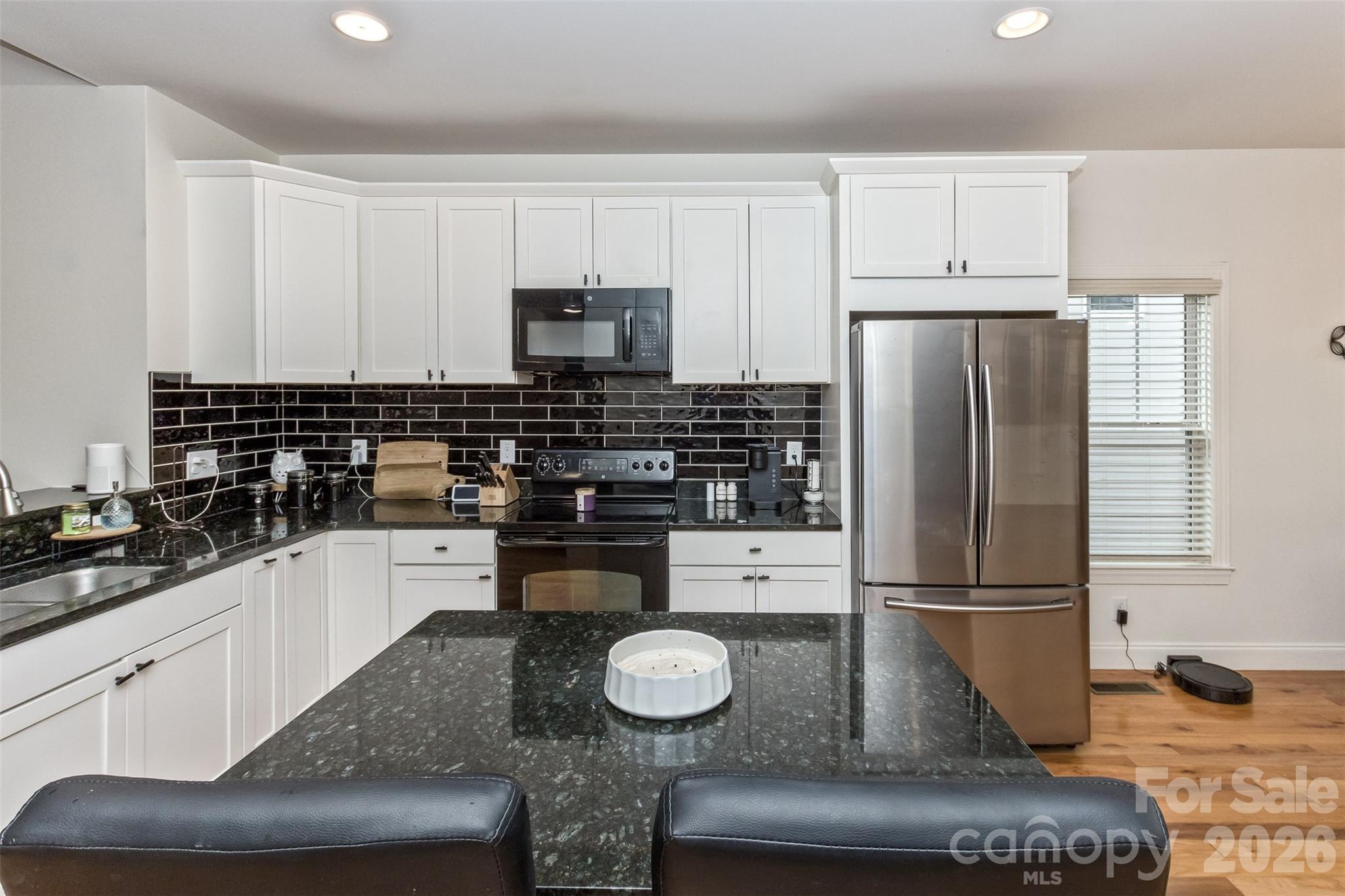 84 Rose Creek Road Leicester, NC 28748 - Photo 8 of 28 a kitchen with granite countertop a sink a stove and refrigerator