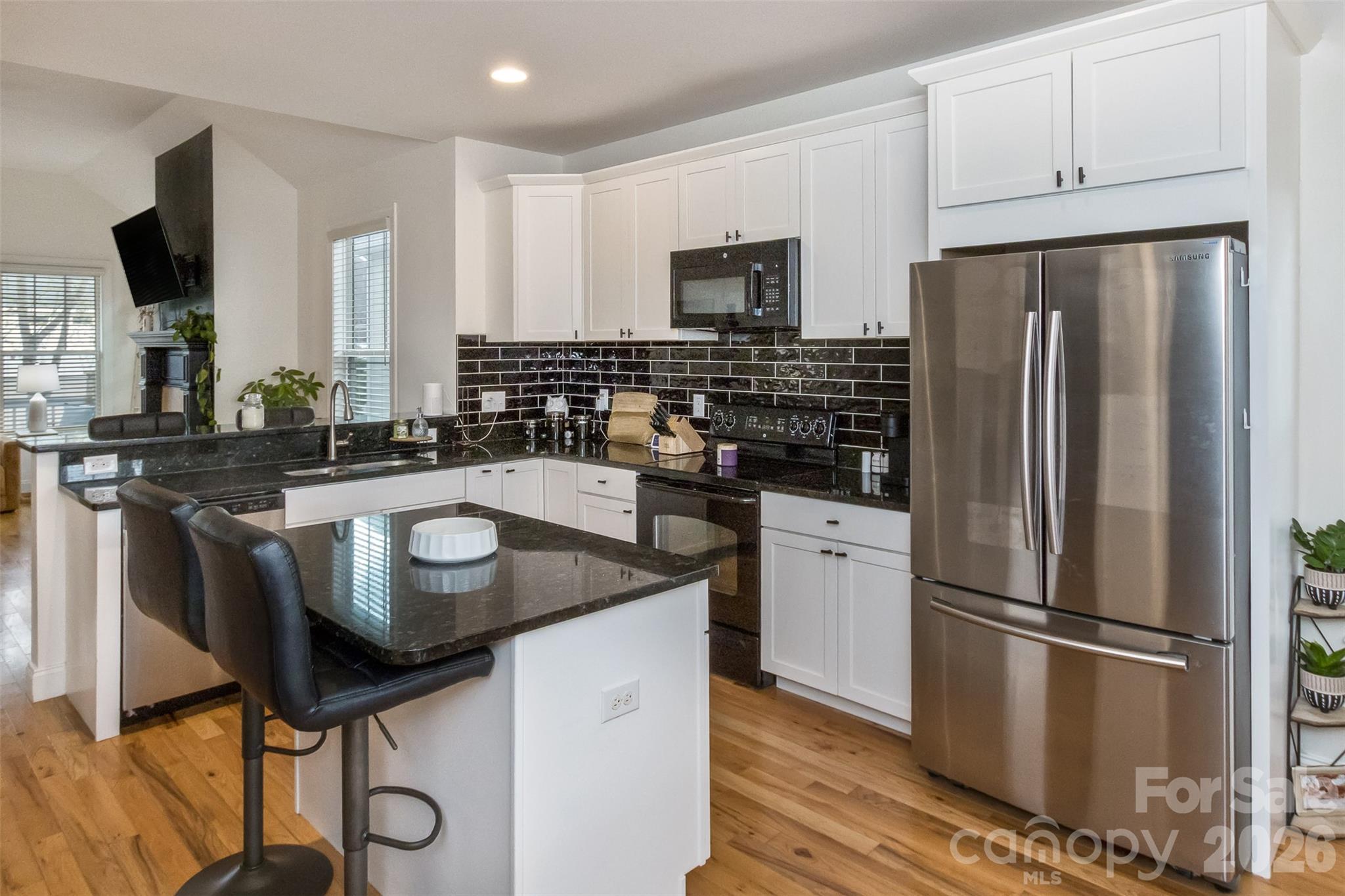 84 Rose Creek Road Leicester, NC 28748 - Photo 9 of 28 a kitchen with kitchen island granite countertop a sink appliances and cabinets