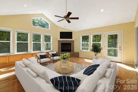 a living room with furniture fireplace and a large window