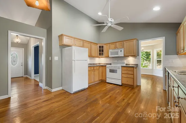 a kitchen with stainless steel appliances a stove a refrigerator cabinets and wooden floor