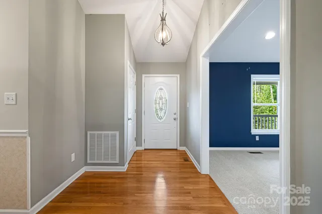 a view of a hallway with wooden floor and a livingroom
