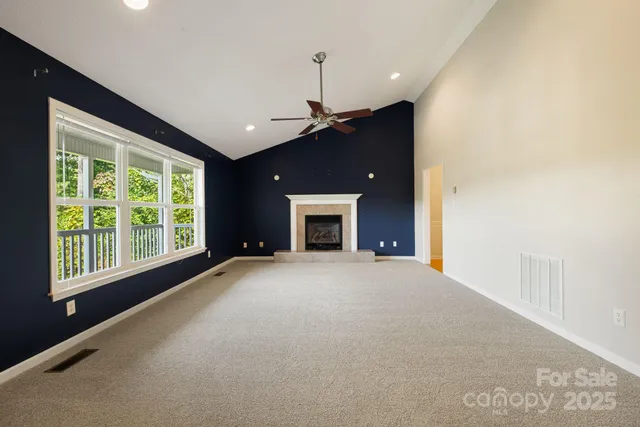a view of an empty room with a fireplace and a window