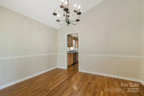 a view of a room with wooden floor and chandelier