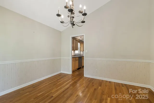 a view of a room with wooden floor and chandelier