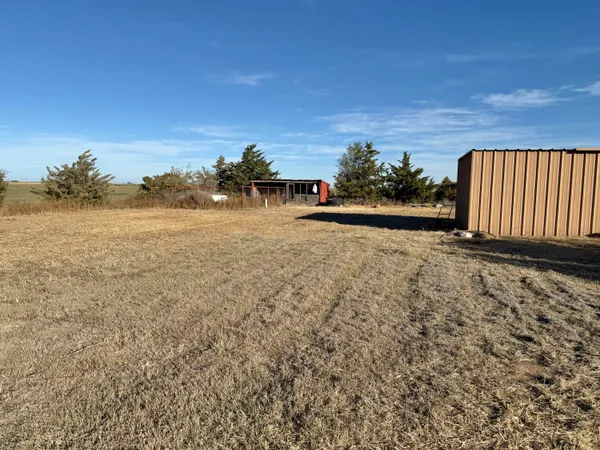 an empty room with wooden floor cabinet and mirror
