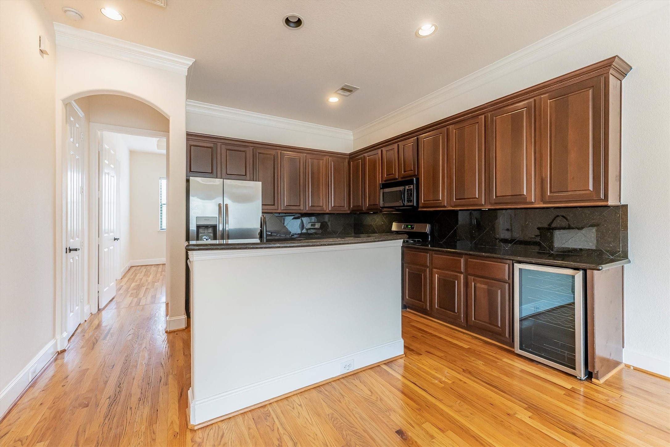 308 Grove Street Houston, TX 77020 - Photo 13 of 28 a kitchen with kitchen island granite countertop wooden floors white cabinets and stainless steel appliances