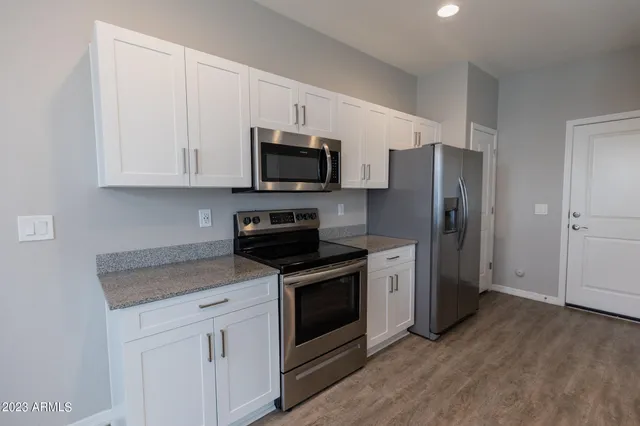 a kitchen with white cabinets and stainless steel appliances