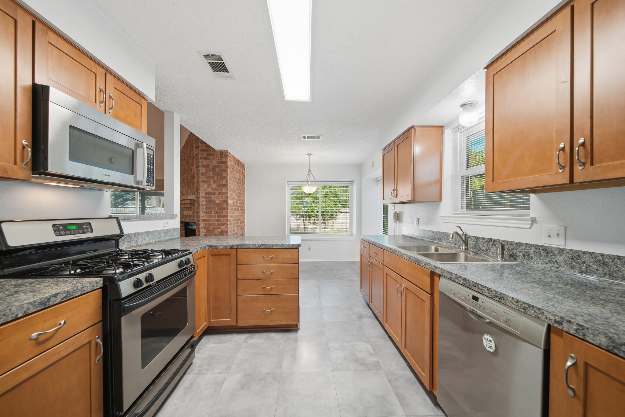 9518 Dundalk Street Spring, TX 77379 - Photo 14 of 46 a kitchen with stainless steel appliances granite countertop a stove a sink and a microwave