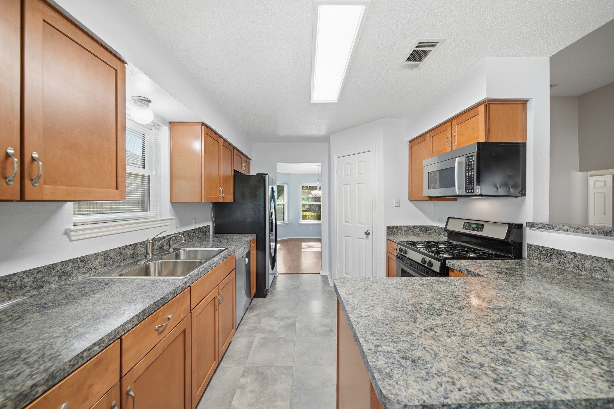 9518 Dundalk Street Spring, TX 77379 - Photo 15 of 46 a kitchen with stainless steel appliances granite countertop a sink stove and refrigerator