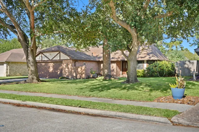 a front view of a house with a garden and trees