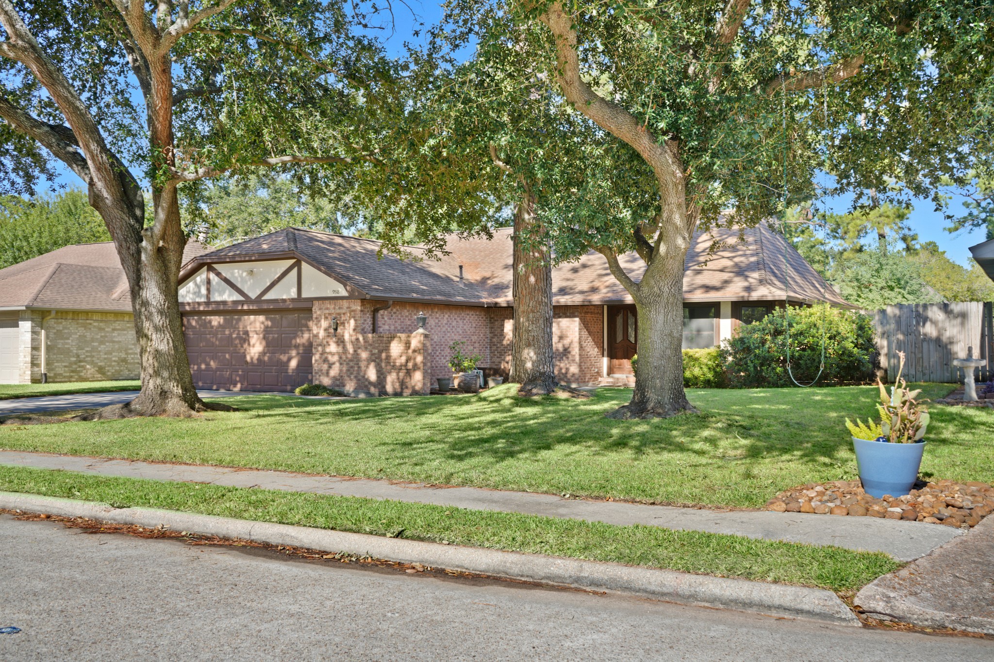 9518 Dundalk Street Spring, TX 77379 - Photo 2 of 46 a front view of a house with a garden and trees