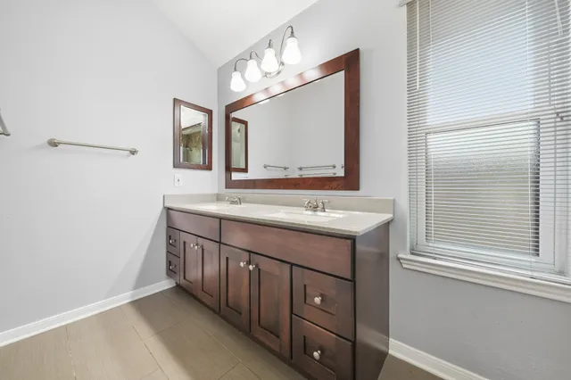 a bathroom with a double vanity sink and a mirror